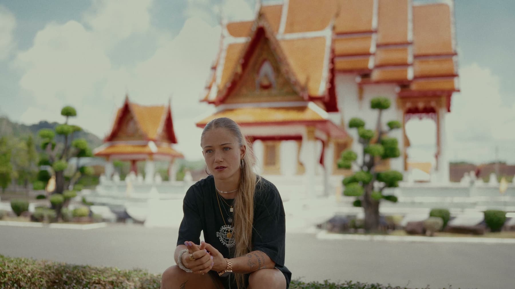 Stella Hemetsberger seated in front of a Thai temple in Phuket